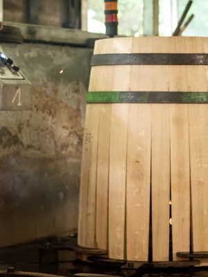 Barrique en cours de chauffe au-dessus d'un brasier de bois de chêne, au poste de chauffe mécanique de l'atelier