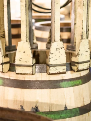 Serrage final des cercles d'une barrique de chêne sous les mâchoires de la presse de l'atelier