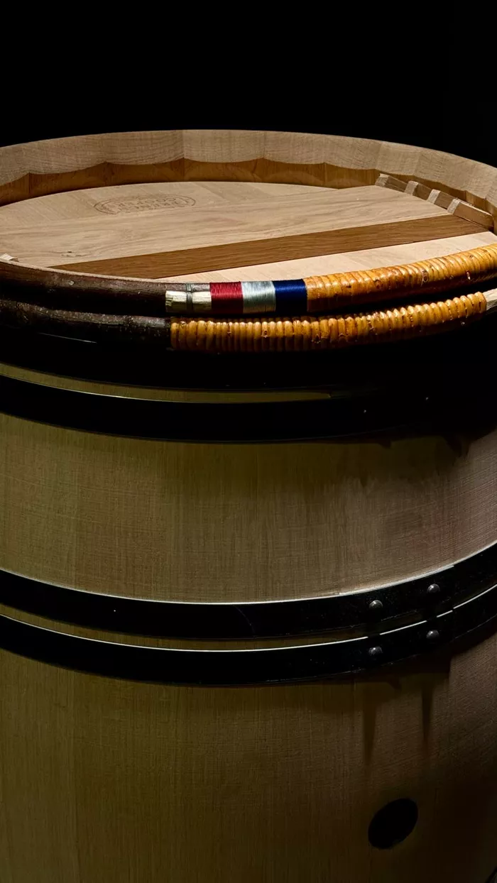 Détail du cerclage de châtaignier tressé de la barrique Tribute et de sa tresse tricolore