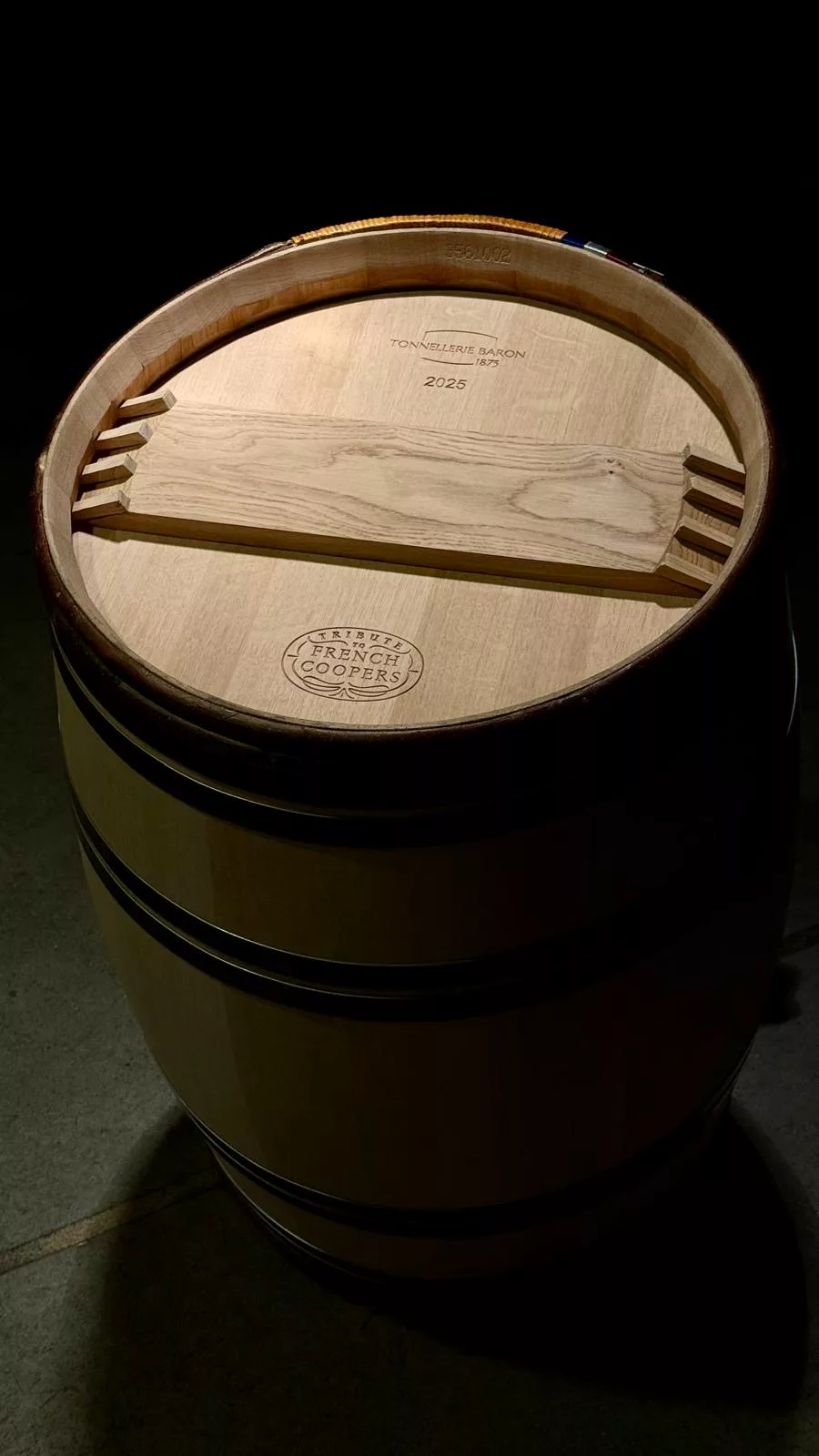 Barrique Tribute to french coopers vue de dessus : fond gravé « Tonnellerie Baron 1875 » et « 2025 », sceau « Tribute to french coopers » et cerclage de châtaignier tressé