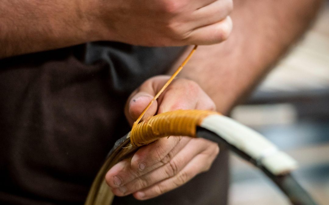 Les mains d’un tonnelier ligaturent un cercle de bois